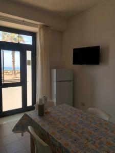 a dining room with a table and a view of the beach at Marger Apartments in Santa Maria di Castellabate +41 photos