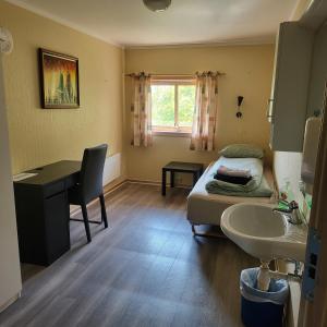 Schlafzimmer mit einem Bett, einem Waschbecken und einem Schreibtisch in der Unterkunft Solvoll in Tønsberg