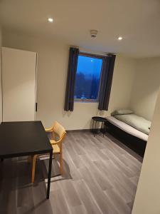 um quarto com uma secretária, uma cama e uma mesa em Solvoll em Tønsberg
