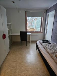 a bedroom with a bed and a desk and a window at Solvoll in Tønsberg