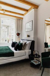 a bedroom with a large white bed and a window at Kerkstraat Residence in Amsterdam