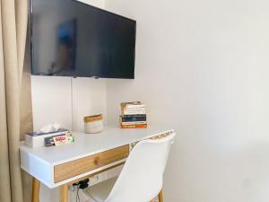 a desk with a tv on a wall with a chair at Maison "Douceurs d'Été" in Vias