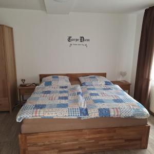 Una cama con edredón en un dormitorio en Gästehaus Kretschmann, en Zeltingen-Rachtig