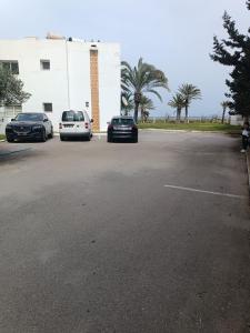 twee auto's geparkeerd op een parkeerplaats naast een gebouw bij Logement S+2 dans un hôtel 4* vue mer in Bizerte