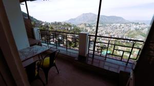 uma varanda com uma mesa e vista para a cidade em Hotel Star View em Solan