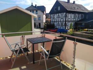 uma varanda com 2 cadeiras e uma mesa no telhado em Ferienhaus in Bad Marienberg Westerwald mit Grill und Terrasse em Bad Marienberg