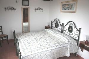 1 dormitorio con 1 cama blanca con marco negro en Ferienhaus in einem Olivenhain, en Rapale