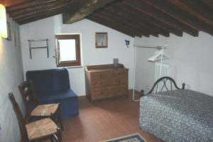 1 dormitorio con cama, silla y vestidor en Ferienhaus in einem Olivenhain, en Rapale