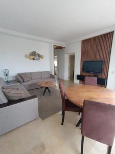 een woonkamer met een tafel en een bank bij Logement S+2 dans un hôtel 4* vue mer in Bizerte