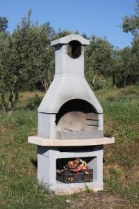 un horno de piedra con un fuego dentro de él en Ferienhaus in einem Olivenhain, en Rapale