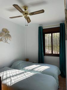 a bedroom with two beds and a ceiling fan at Ellaure in Monda