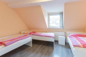 2 łóżka w małym pokoju z oknem w obiekcie Messe Monteurzimmer Köln w Kolonii
