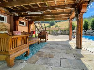 a wooden pergola with a bench on a patio at Ferienhaus Kappel mit Pool in Freiburg im Breisgau