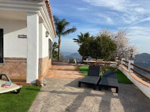 a patio with chairs and tables on a house at Ellaure in Monda