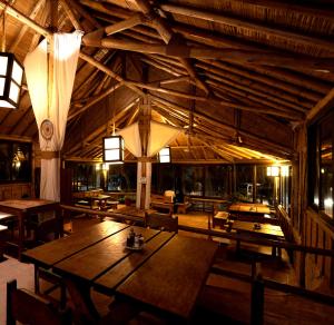 a room with wooden tables and chairs in a building at Las Cabañas de Antica in Vichayito