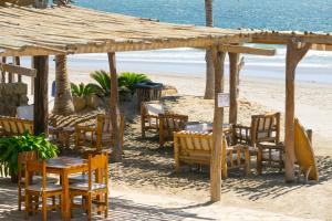 un grupo de mesas y sillas en la playa en Las Cabañas de Antica, en Vichayito