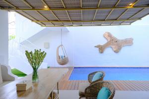 Habitación con mesa, sillas y piscina en Villa Hanara - Unique 2BR Mediterranean, en Uluwatu