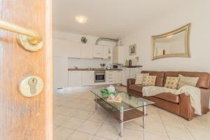ein Wohnzimmer mit einem Sofa und einem Tisch in der Unterkunft Golden View Apartment in Perledo