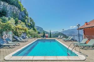 Una piscina con tumbonas al lado de una casa. en Golden View Apartment, en Perledo