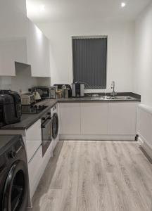 a kitchen with a sink and a washing machine at Contemporary Double Ensuite Room in Birmingham