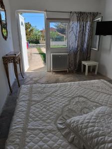 a bed in a bedroom with an open door at Ξενώνας in Nea Kalikratia