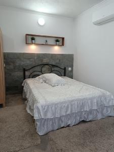 a bedroom with a large bed with a headboard at Ξενώνας in Nea Kalikratia