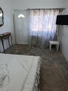 a bedroom with a bed and a door with a window at Ξενώνας in Nea Kallikrateia