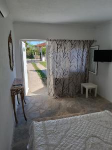 a bedroom with a bed and an open door at Ξενώνας in Nea Kallikrateia