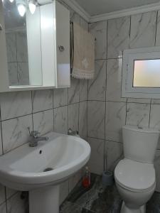a bathroom with a white sink and a toilet at Ξενώνας in Nea Kalikratia