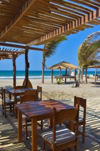 un gruppo di tavoli e sedie sulla spiaggia di Las Cabañas de Antica a Vichayito