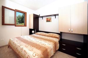 een slaapkamer met een bed, een kast en een raam bij Ferienhaus in kleiner Ferienanlage mit Garten, Parkplatz und Kinderschwimmbad in Peschici
