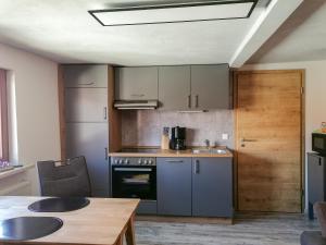 a kitchen with gray cabinets and a wooden table at Ferienwohnung Andrea in Hasselfelde