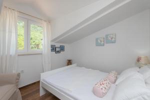 a white bedroom with a bed and a window at Ferienwohnung für 2 Personen ca 58 qm in Orebić, Dalmatien Süddalmatien in Orebić