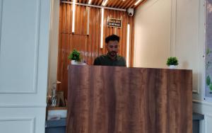 a man standing behind a counter in an office at HOTEL INDIA HOUSE in Dharamshala