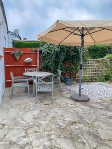 eine Terrasse mit einem Sonnenschirm, einem Tisch und Stühlen in der Unterkunft Beautiful and spacious home in London
