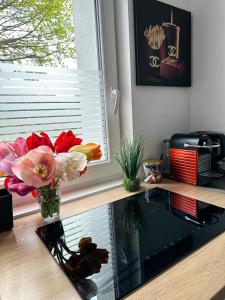 a vase of flowers on a counter next to a window at Deluxe Apartement mit Terrasse in Duisburg