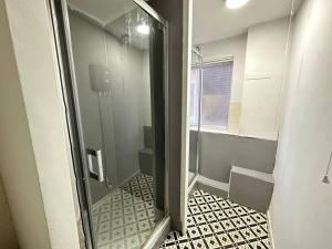 a bathroom with a shower with a glass door at Cosy Retreat: Near Attractions & Comfortable! in Birmingham