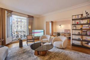 uma sala de estar com mesa e cadeiras em Apartment Arc de Triomphe/ Champs Elysée by Studioprestige em Paris