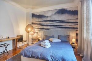 um quarto com uma cama azul com toalhas em Apartment Arc de Triomphe/ Champs Elysée by Studioprestige em Paris