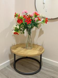 a vase of flowers sitting on a round table at Stylish Living: 1BR Apt near MCR Central in Manchester