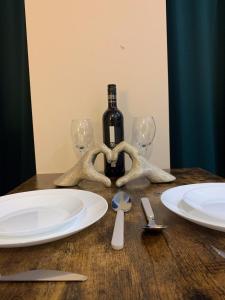 a table with a bottle of wine and two glasses at Stylish Living: 1BR Apt near MCR Central in Manchester