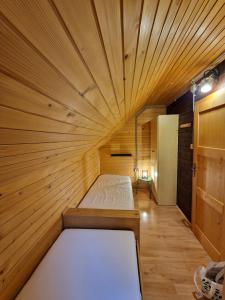 ein kleines Zimmer mit einem Bett in einem Holzzimmer in der Unterkunft Forest Apartments Pokljuka in Zgornje Gorje