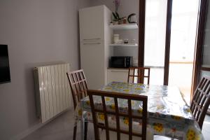 a dining room with a table and chairs and a kitchen at Casa Le corti in Livorno