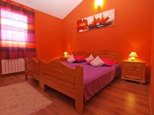 Schlafzimmer mit einem Holzbett mit orangefarbenen Wänden in der Unterkunft Studio für 4 Personen ca 42 qm in Pula, Istrien Istrische Riviera in Pula
