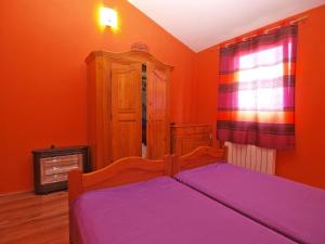 Schlafzimmer mit orangefarbenen Wänden und einem Bett mit lila Laken in der Unterkunft Studio für 4 Personen ca 42 qm in Pula, Istrien Istrische Riviera in Pula