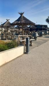 塞特港的住宿－mobil home le castellas Bertrand /stehlin，海滩上一组带遮阳伞的野餐桌