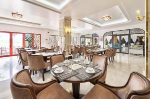 un restaurante con mesas, sillas y ventanas en Harry Phu Quoc Hotel 3, en Phu Quoc