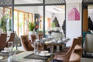 een eetkamer met tafels, stoelen en ramen bij Harry Phu Quoc Hotel 3 in Phu Quoc