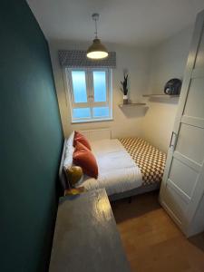 een kleine slaapkamer met een bed en een raam bij Super-convenient, 3 mins to Kings Cross in Londen