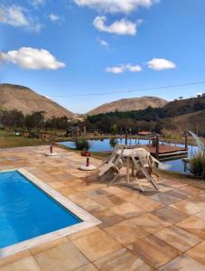 a swimming pool with a slide and a playground at Pousada valle do chalé in Capitólio